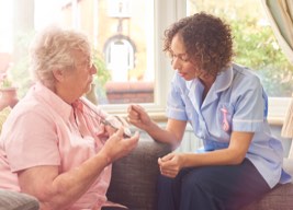 Elderly woman discussing PERS monitor with nurse